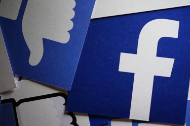 A banner displaying Facebook's logo with blue thumbs down emojis surrounding it. 